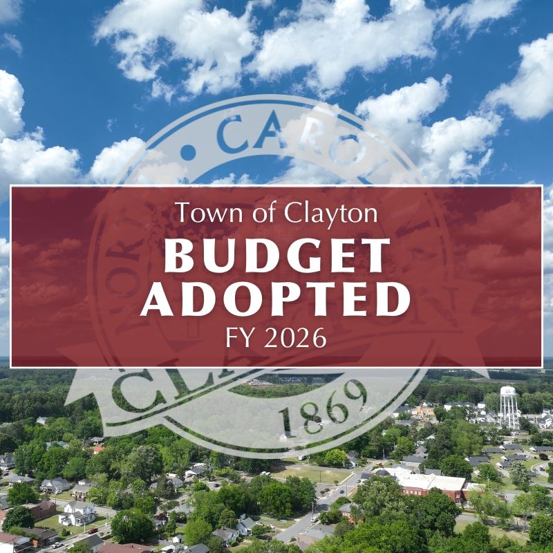 text boxt reads town of clayton budget adopted fy26 overlayiong town seal & aerial photo of clayton