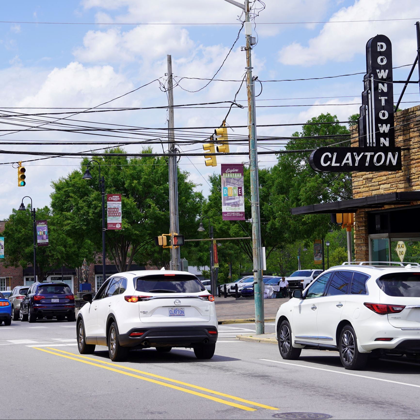 Downtown Clayton, North Carolina, featuring a street view with cars driving & parked along the road