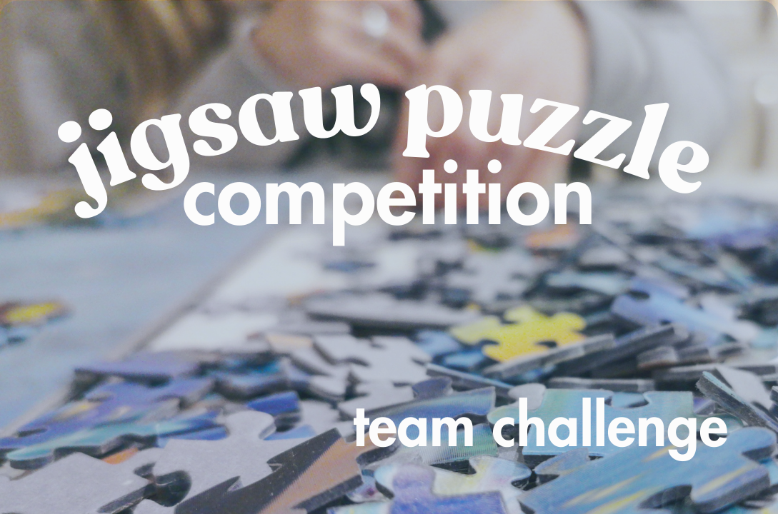 jigsaw puzzle competition, team challenge. image with puzzle pieces on table with hands in backgroun