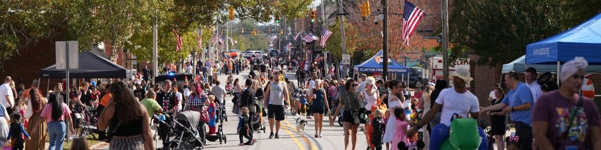 Families dressed in costumes walk main street to trick or treat